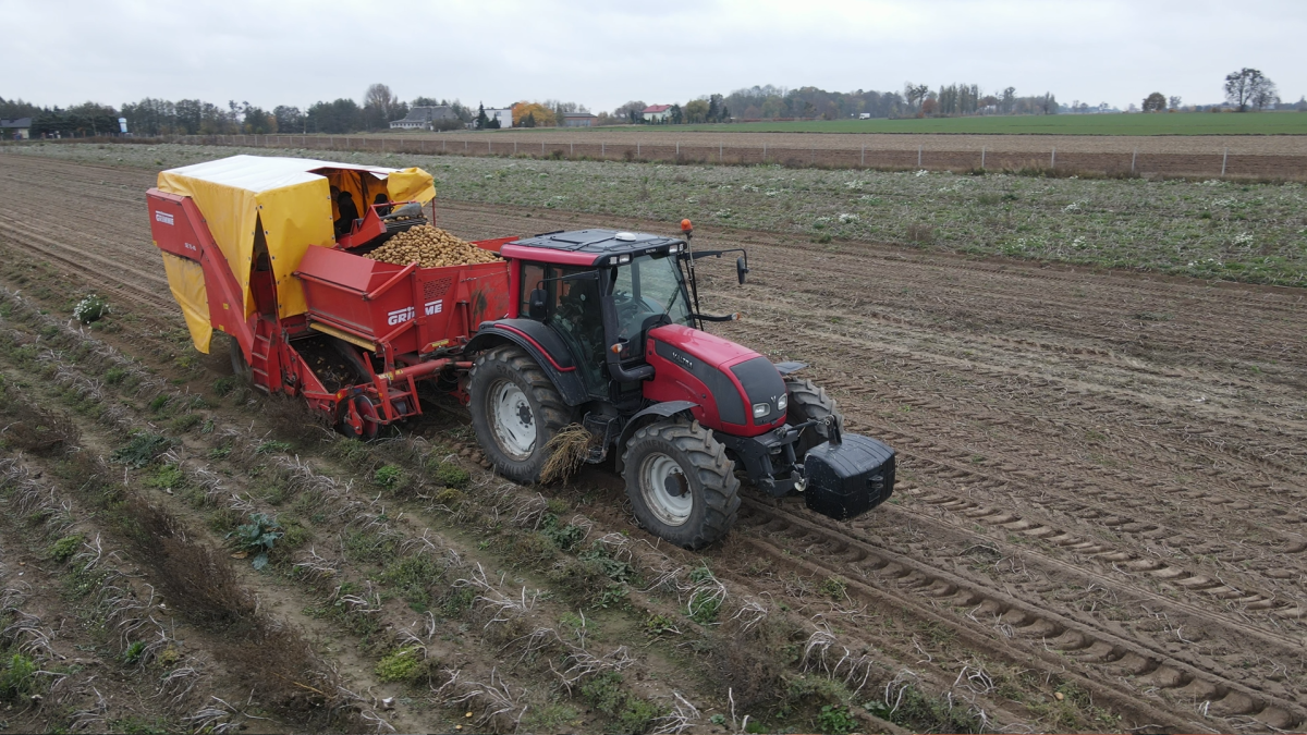"Zdjęcie młodego rolnika z województwa łódzkiego, który korzysta z nowoczesnych technologii w swoim gospodarstwie, łącząc tradycję z innowacją. W tle widoczne zaawansowane maszyny rolnicze oraz zadbane pola, co odzwierciedla dynamiczny rozwój młodych rolników w Polsce."