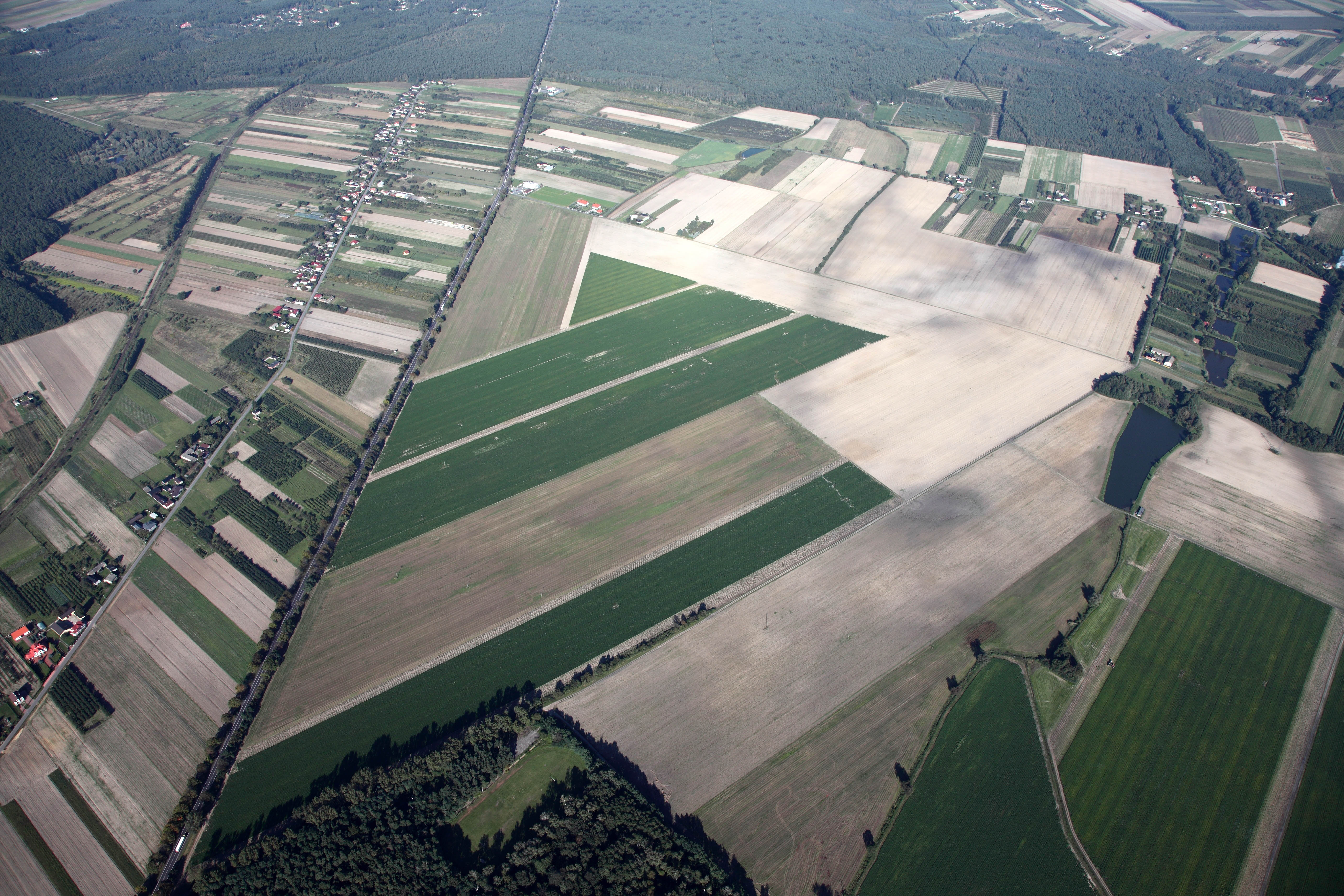 "Zdjęcie przedstawia panoramiczny widok na Stryków, gdzie trwa intensywne przygotowanie obszaru inwestycyjnego we współpracy z Łódzką Specjalną Strefą Ekonomiczną. Fotografia ilustruje dynamiczny rozwój regionu, w szczególności w okolicy Bratoszewic i Wyskoków, co podkreśla znaczenie tego projektu dla lokalnej gospodarki."