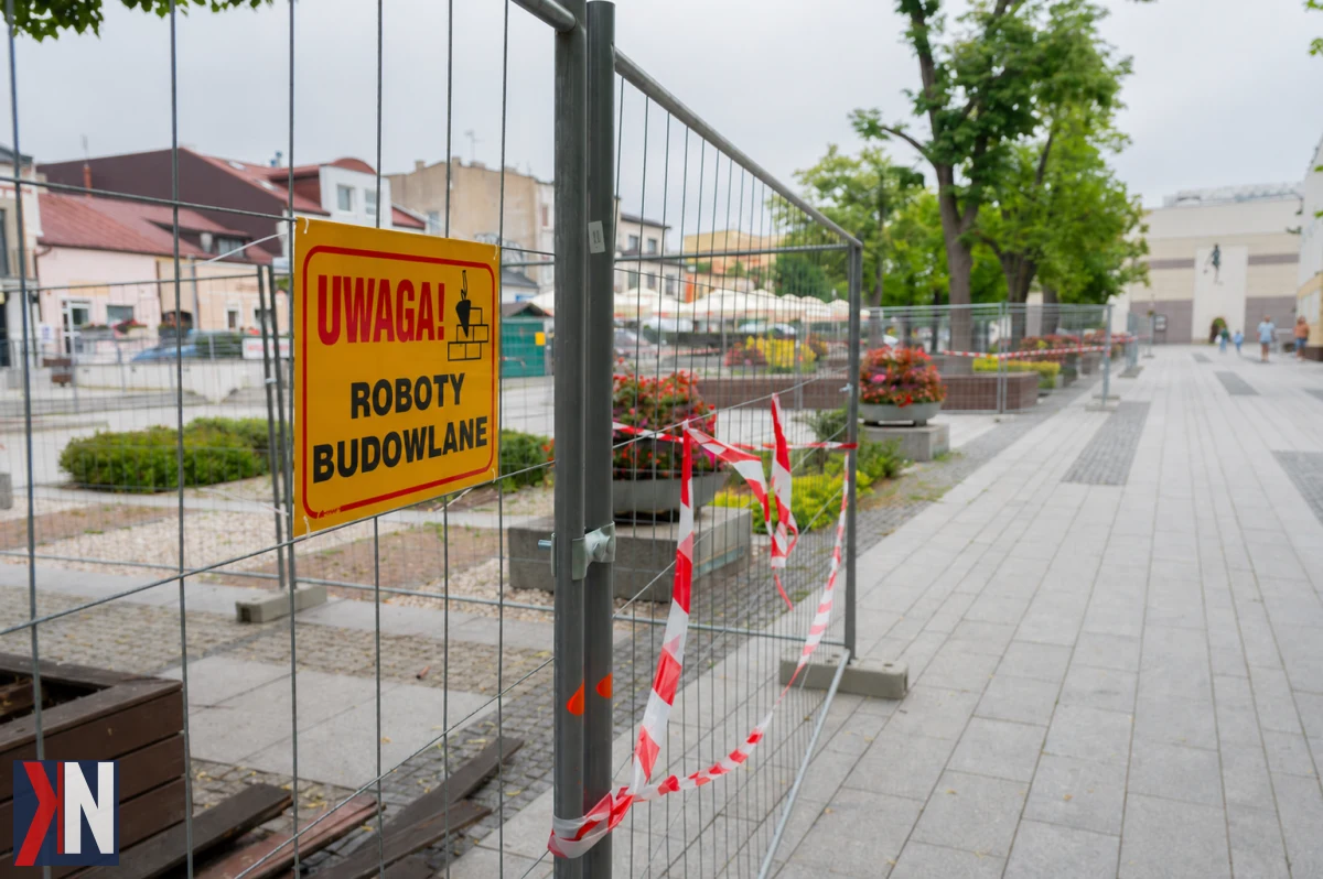 "Zdjęcie przedstawiające plac Narutowicza w Bełchatowie, gdzie trwają prace nad przebudową. Zdemontowane stare drewniane podesty to pierwszy krok w kierunku stworzenia większej ilości zieleni i nowych miejsc do odpoczynku dla mieszkańców i turystów."