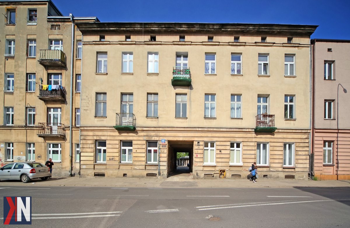 "Zdjęcie przedstawiające jedną z kamienic w centrum Łodzi, która zostanie poddana gruntownemu remontowi w ramach programu Biura Rewitalizacji UMŁ. W tle widoczne są tradycyjne architektoniczne detale, symbolizujące bogatą historię miasta. Projekt obejmuje 217 mieszkań w dziewięciu kamienicach, które przywrócą życie tej urokliwej części Łodzi."