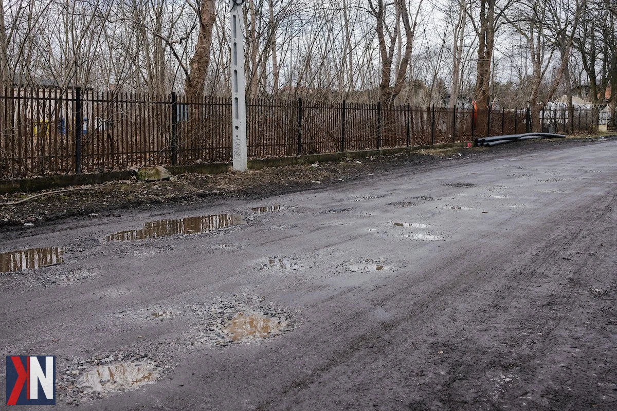 "Zdjęcie przedstawia ekipę drogowców pracujących na ul. Dąbrowa w Łodzi, gdzie trwają prace związane z inwestycjami drogowymi i rowerowymi. W tle widać oznakowanie budowy oraz pojazdy służbowe, co symbolizuje powrót budowniczych na ulice miasta wraz z nadejściem wiosny."