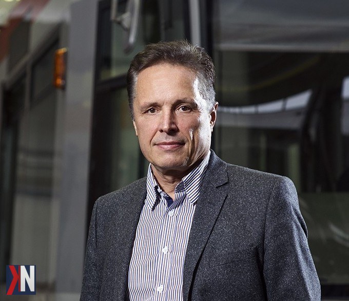 "Prezentacja miasta Łódź z widocznymi środkami komunikacji zbiorowej, z rozmową Zbigniewa Papierskiego, prezesa MPK Łódź, jako tłem dla dyskusji na temat wyzwań i rozwoju transportu publicznego w regionie."