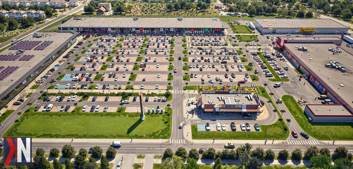 "Panorama parku handlowego BIG Konstantynów, z widocznymi lokalami w trakcie przygotowań do otwarcia oraz ekipą pracującą nad finalizacją budowy, pod Łodzią. Zdjęcie ilustruje postępy w rekrutacji menedżera obiektu oraz przekazywaniu lokali najemcom, zgodnie z informacjami przekazanymi przez KNews.pl."