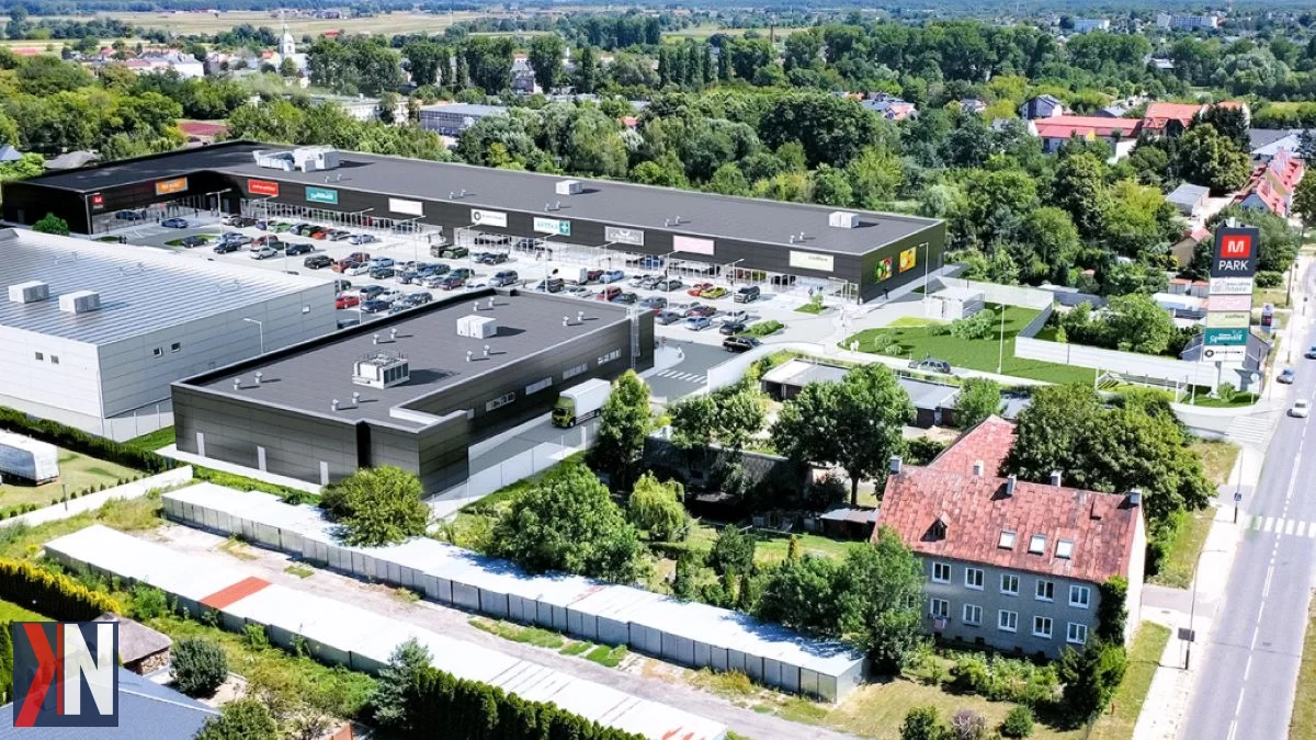 "Zdjęcie przedstawia radosną atmosferę podczas wielkiego otwarcia M Parku w Ozorkowie, nowoczesnego centrum handlowego, które ma potencjał na stać się kluczowym miejscem zakupowym w północnej części aglomeracji łódzkiej. Na zdjęciu widać tłumy ludzi, kolorowe dekoracje i stoiska, symbolizujące różnorodność oferty, jaką M Park zapewnia swoim klientom."