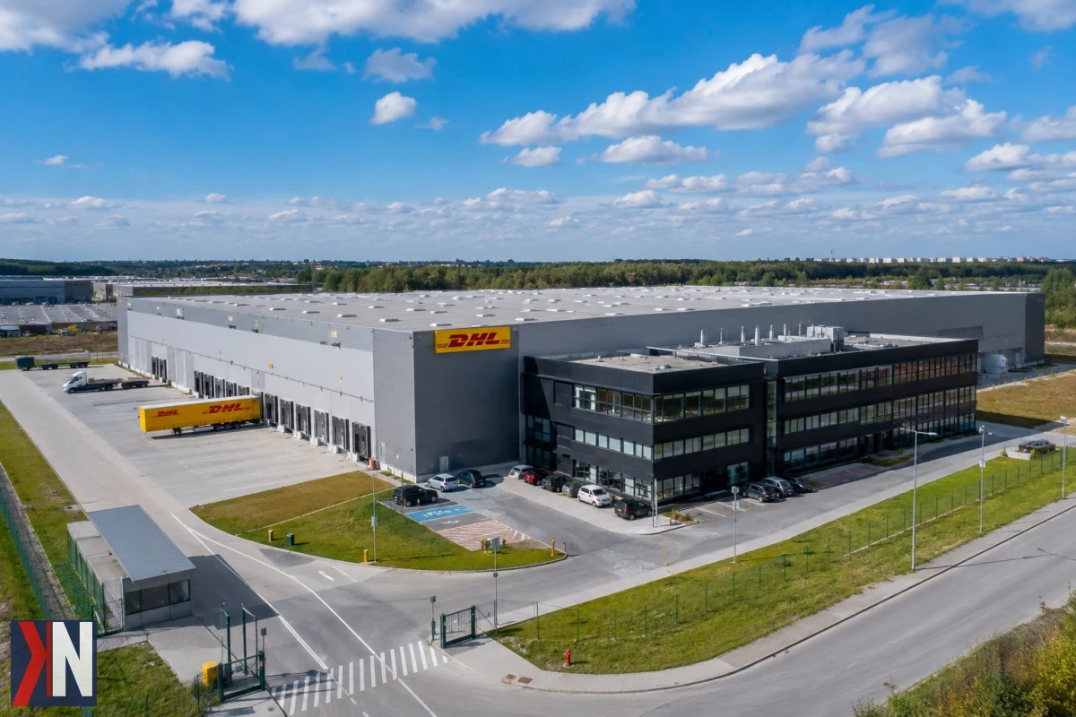 Zdjęcie przedstawia nowoczesne centrum logistyczne DHL w Zgierzu, które wkrótce rozpocznie działalność jako centrum obsługi przesyłek. Budynek, wynajęty przez DHL eCommerce Polska, znajduje się w kompleksie Hillwood Zgierz I i ma na celu wzmocnienie zaplecza logistycznego północnej części aglomeracji Łodzi.