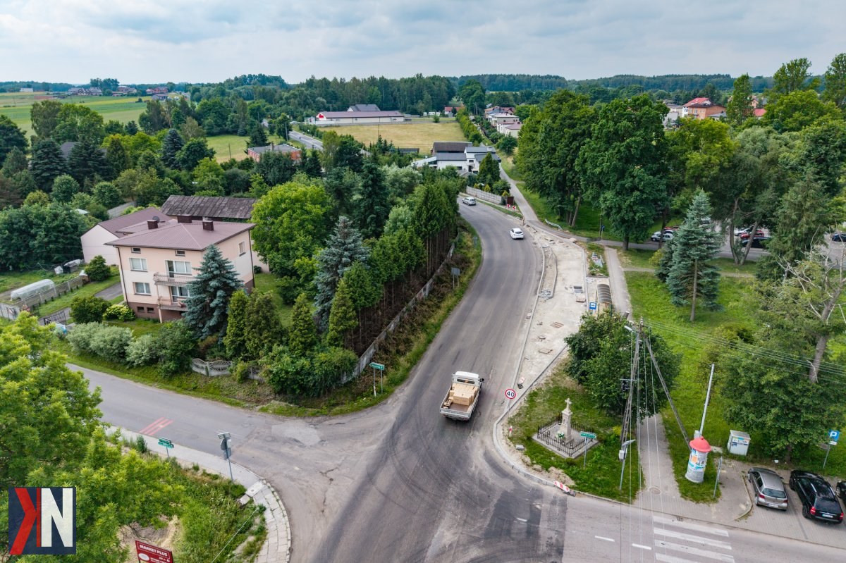"Remont drogi wojewódzkiej nr 485 między Drużbicami a Czarnym Lasem - prace modernizacyjne w toku, ukazujące sprzęt budowlany i ekipę fachowców na terenie województwa łódzkiego."