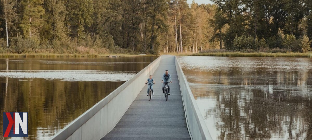"Rowerzysta na malowniczej ścieżce w Szwecji, prowadzącej tuż nad taflą jeziora. Ścieżka ta zdobyła uznanie w europejskich mediach dzięki swoim niezwykłym widokom i atrakcyjnemu położeniu."