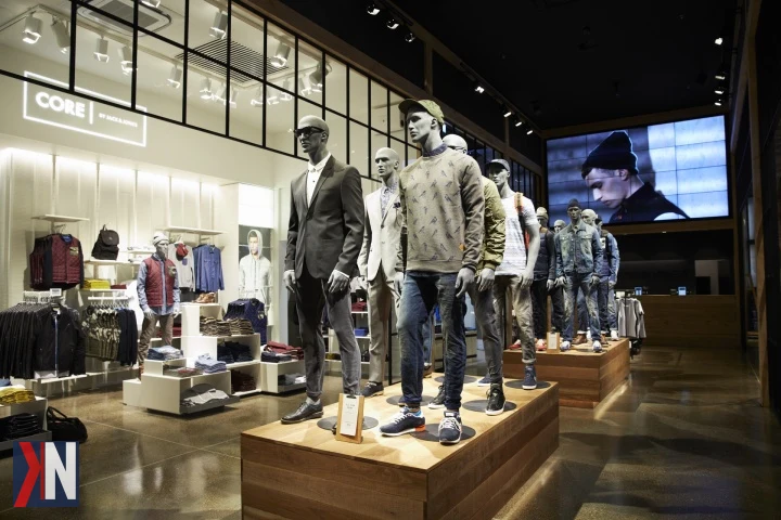 Zdjęcie przedstawia nowo otwarty jubileuszowy salon JACK & JONES w Rzgowie, który jest dziesiątym outletem marki w Polsce. W tle widać nowoczesne wnętrze sklepu, pełne stylowych ubrań męskich. Otworzenie salonu odbywa się w Ptak Outlet, co wskazuje na rozwój duńskiej marki w polskim rynku.
