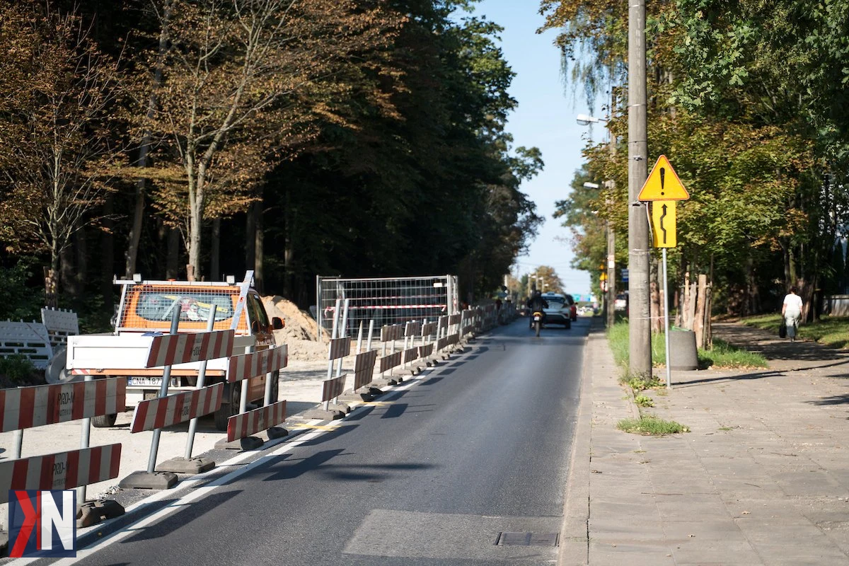 Remont ulicy Pojezierskiej w Łodzi - prace nad nowym wodociągiem i budową chodników. W tle widok na ekipy budowlane przy pracy, z przygotowaniami do przebudowy przystanków autobusowych. Z czasem drogowcy przeniosą się na ulicę Zgierską.