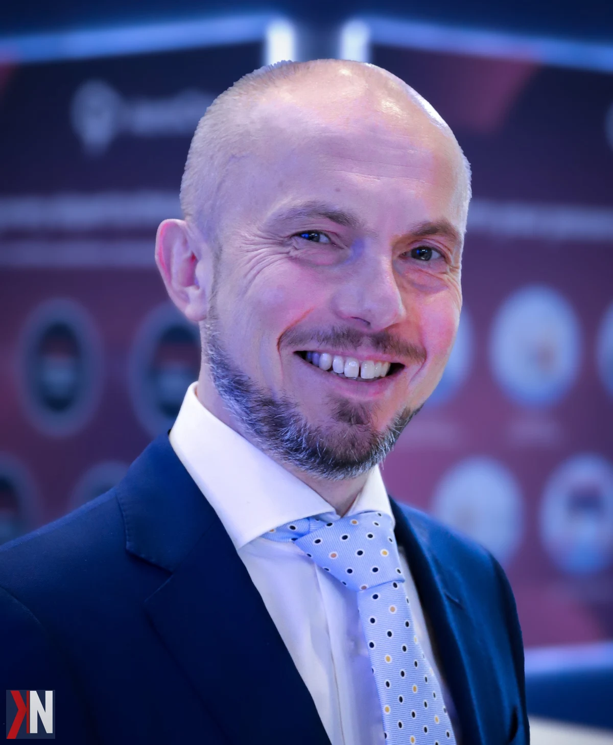 Paweł Zagrajek, dyrektor Biura Operacyjno-Handlowego Port Polska, omawia plany rozwoju nowego centralnego lotniska i węzła logistycznego, który ma na celu zatrzymanie ładunków cargo uciekających z Polski na Zachód. W tle widoczna koncepcja portu z transportem kolejowym i drogowym.