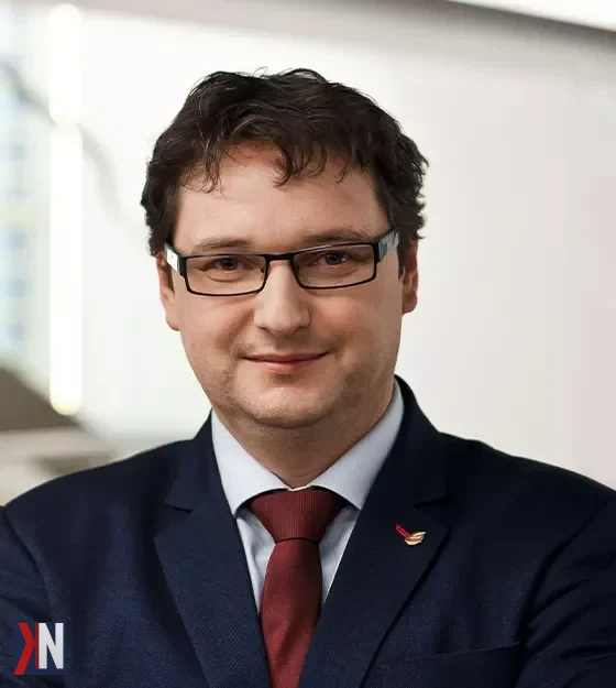 Zdjęcie przedstawia autora artykułu 'Wszyscy mamy takie samo szczęście. Różnimy się tym, czy umiemy je wykorzystać' w chwili refleksji, stojącego w biurze z raportem w ręku. Zanim rozpoczął swoją podróż jako przedsiębiorca, zdobywał cenne doświadczenie w korporacjach, gdzie dostrzegano jego talent do zarządzania, co skłoniło go do wykorzystania swojego potencjału w własnym biznesie.