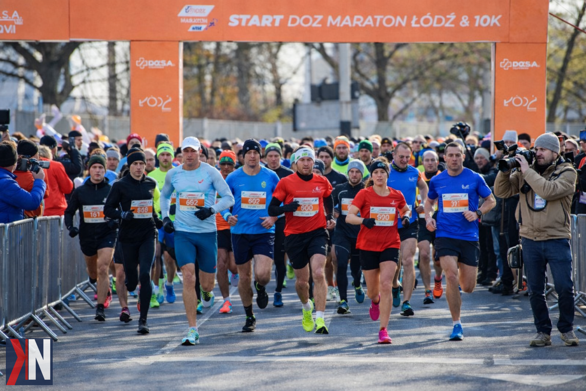 "Łódź szykuje się na DOZ Maraton - zmiany w ruchu i komunikacji miejskiej, zdjęcie przedstawiające miejskie ulice z plakatami promującymi wydarzenie. Fotografia ilustruje przygotowania miasta na nadchodzący maraton."