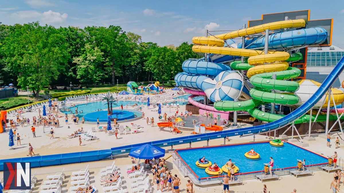 Na zdjęciu przedstawiono nowoczesny aquapark Fala w Łodzi, który planuje rozbudowę sieci wodnych atrakcji. Obiekt jest kluczowym elementem ambitnego programu inwestycyjnego, mającego na celu rozwój rekreacji i atrakcji wodnych w regionie. W tle widać radosne rodziny korzystające z rozrywek wodnych, co odzwierciedla wizję spółki o tworzeniu wyjątkowych miejsc wypoczynku dla mieszkańców i turystów.