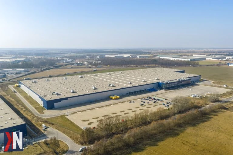 Zdjęcie przedstawia nowoczesny magazyn EQT Park w Poznaniu, który został wynajęty przez platformę BESTSECRET. Obiekt zajmuje imponującą powierzchnię 108 tys. mkw., co stanowi jedną z największych umów magazynowych roku. Wnętrze magazynu jest dostosowane do potrzeb dystrybucji odzieży premium i luksusowej.