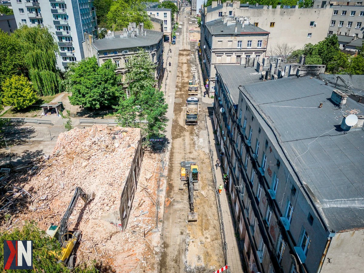 "Zdjęcie przedstawiające odkryte fundamenty i fragment muru podczas przebudowy ul. Franciszkańskiej w Łodzi, ilustrujące archeologiczne ślady dawnej zabudowy miasta, które zostały ujawnione przez drogowców."