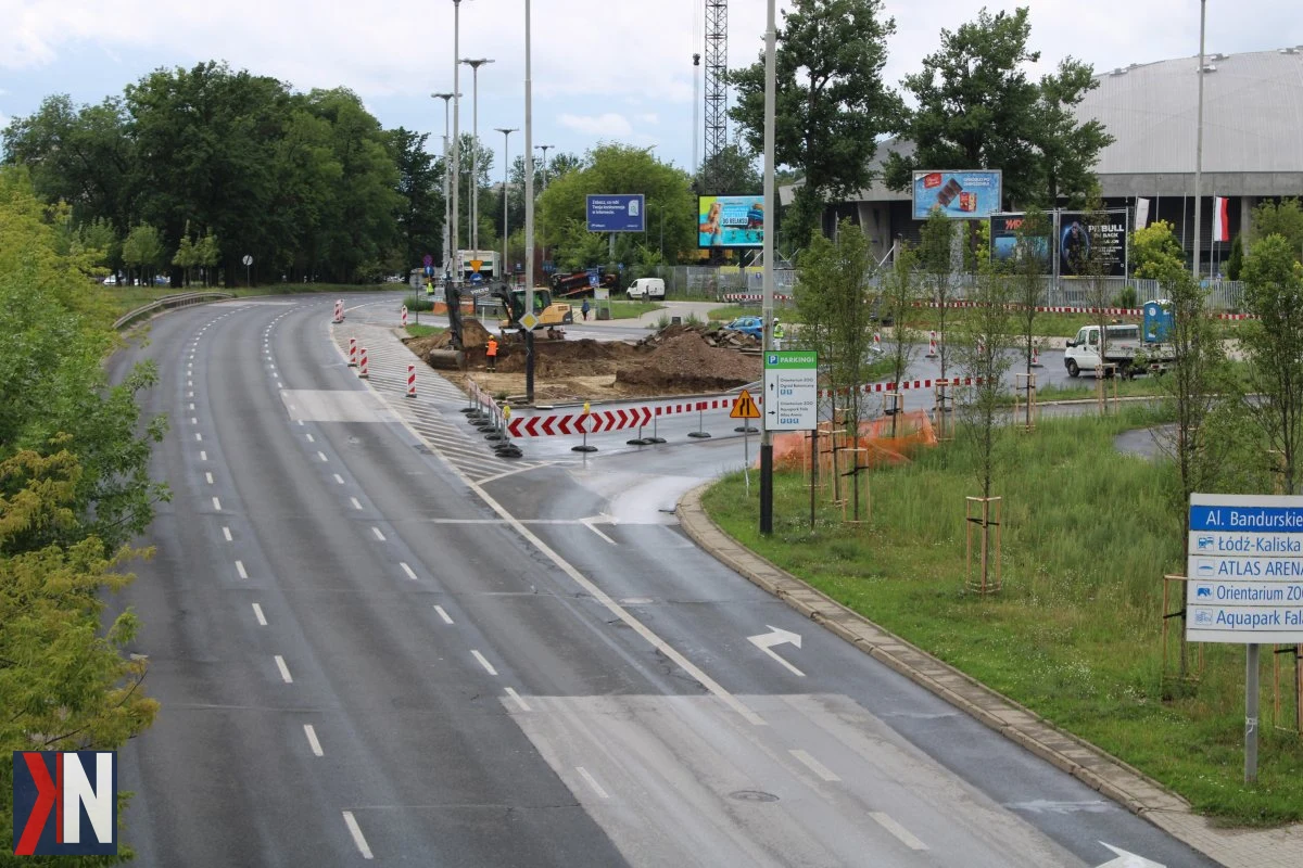 "Zbliżenie na teren budowy komory stalowej K5 przy Atlas Arenie w Łodzi, gdzie trwają intensywne prace przygotowawcze. Widoczny plac budowy i sprzęt budowlany zapowiadają nowy etap inwestycji, która zmieni okolicę w kierunku Retkini."