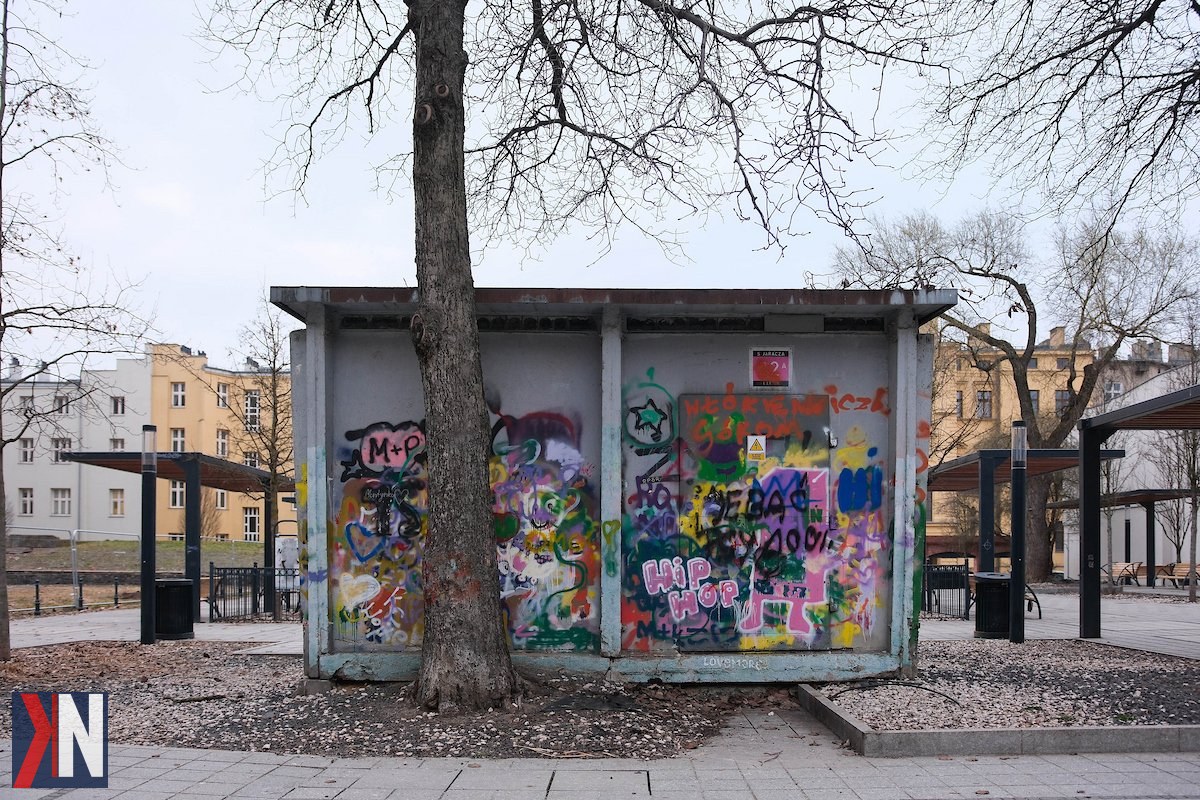 "Zdjęcie przedstawia ażurowe obudowy stacji transformatorowych w centrum Łodzi, w Pasażu Hilarego Majewskiego i przy ul. Włókienniczej. Nowoczesne stalowe konstrukcje w kształcie 'lampionów' dodają architektonicznego uroku, jednocześnie zakrywając nieestetyczne elementy infrastruktury miejskiej."