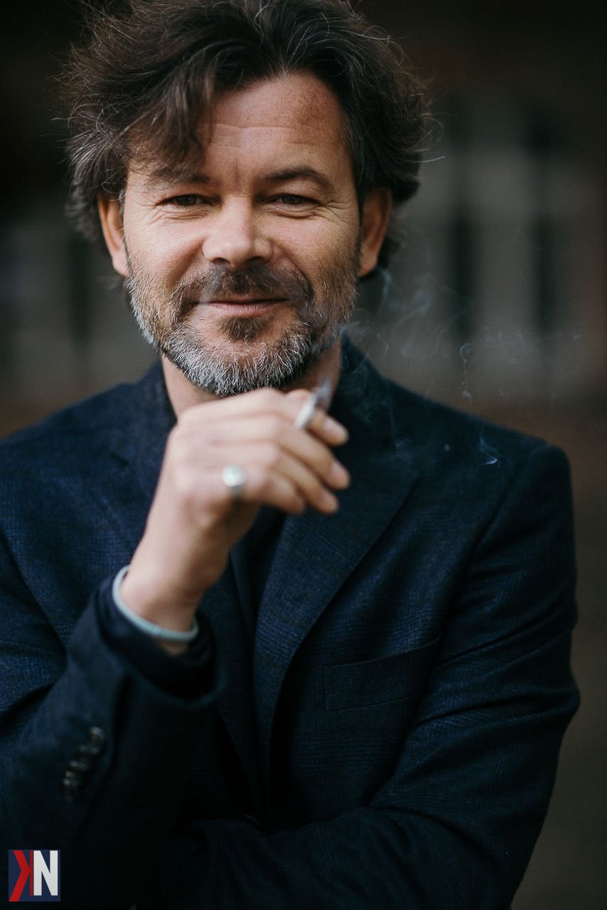 "Fotografka kobiecych dusz w kawiarni Costa w Manufakturze w Łodzi, otoczonej pofabrycznym wnętrzem z wysokimi sufitami i surową cegłą, podczas intymnej rozmowy przy stole. Idealne miejsce na kreatywną sesję zdjęciową."