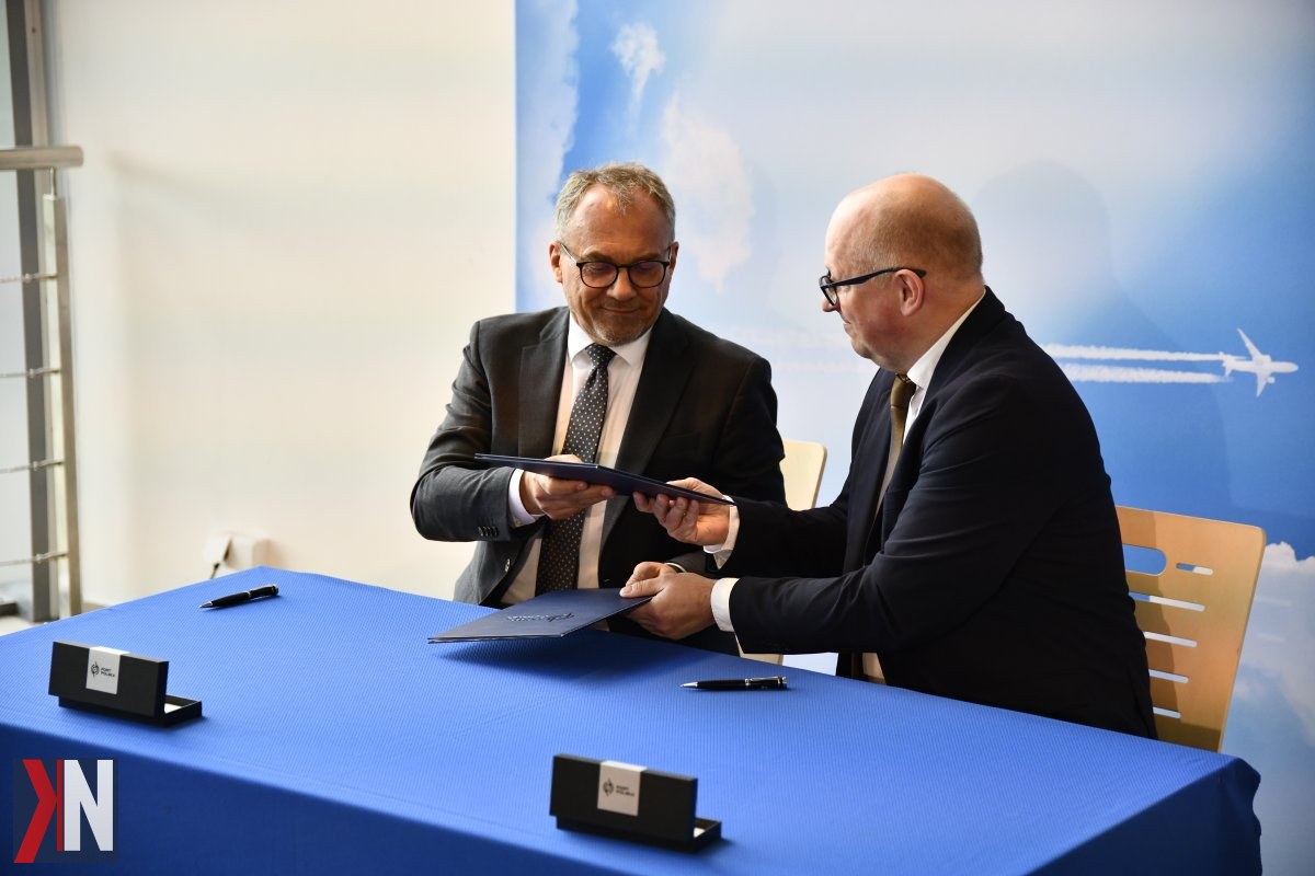 "Port Polska i łódzkie lotnisko - zdjęcie z podpisania listu intencyjnego o współpracy, symbolizujące rozwój nowoczesnego systemu transportu lotniczego w Polsce Centralnej. Na zdjęciu przedstawiciele spółki Centralny Port Komunikacyjny i Portu Lotniczego Łódź, którzy omawiają plany dotyczące budowy infrastruktury wspierającej transport lotniczy w regionie."