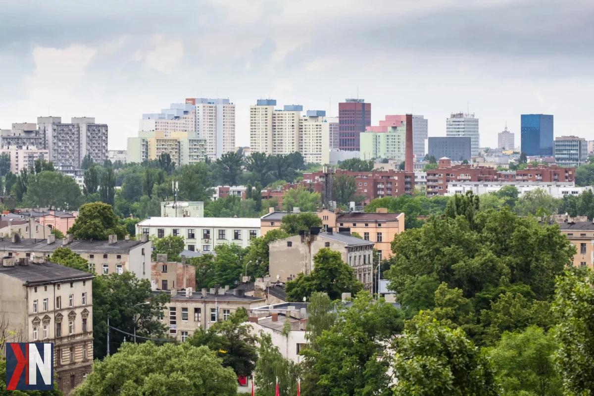 Zdjęcie przedstawiające panoramiczny widok na dzielnicę Polesie w Łodzi, ilustrujące temat artykułu o cenach mieszkań. Na zdjęciu widać nowoczesne budynki oraz zielone tereny, co podkreśla atrakcyjność tej lokalizacji. Artykuł analizuje wyniki badania cen transakcyjnych mieszkań w Łodzi przeprowadzone przez serwis Wycenowo.pl.