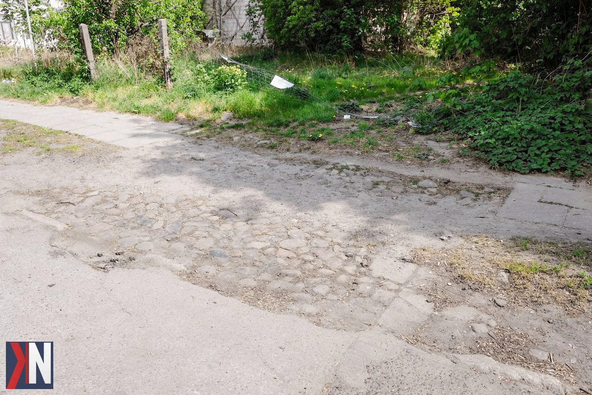 "Remont ul. Łomżyńskiej w Łodzi - prace na kluczowym łączniku Górniaka i Dąbrowy, maj 2023. Widok na ul. Łomżyńską z oznaczeniem remontu, w tle pojazdy i robotnicy przygotowujący się do prac."