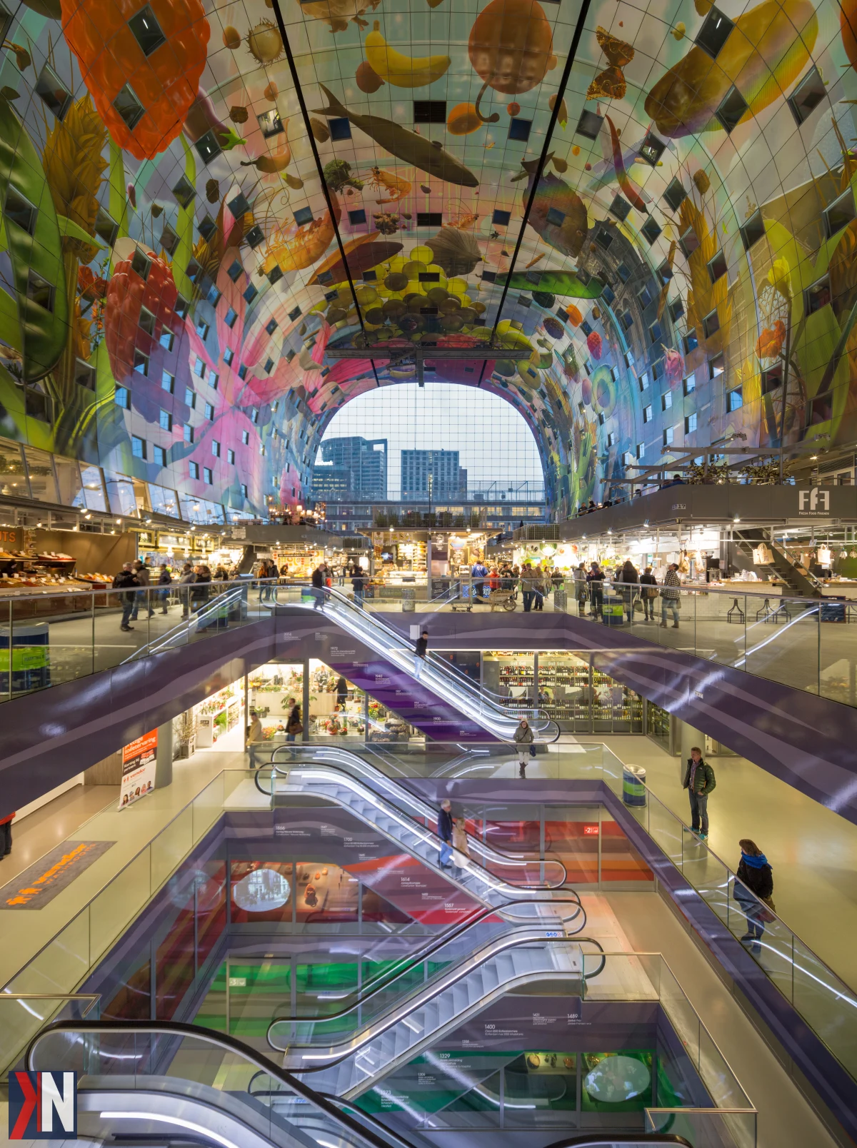 "Zewnętrzny widok Markthal w Rotterdamie, ikonicznego budynku otwartego w 2014 roku, który przyciąga rocznie 8,5 miliona odwiedzających. Zdjęcie ukazuje nowoczesną architekturę i tłumy ludzi cieszących się unikalnym doświadczeniem kulinarnym i społecznym w sercu miasta."