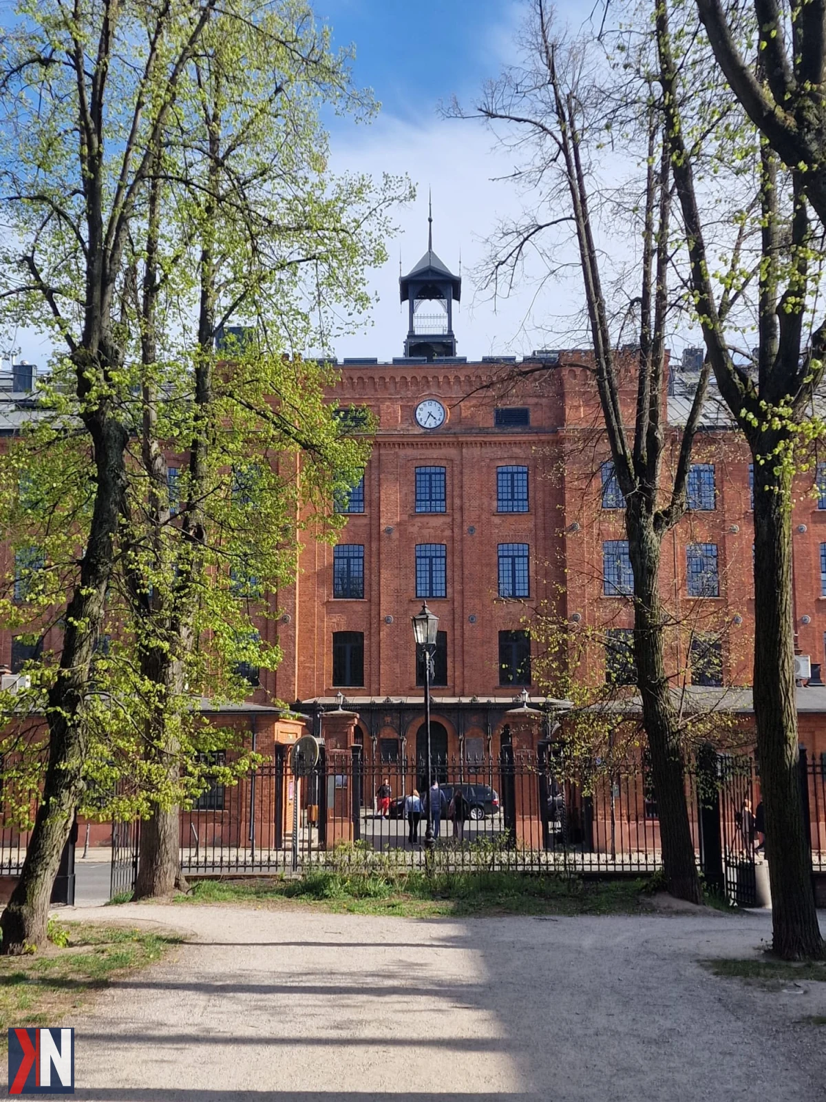 Zdjęcie przedstawia Księży Młyn, dzielnicę z dynamicznymi zmianami. Widać remontowane ulice, zadbane parki oraz tereny po fabrykach, które ożywają. Powrót życia kulturalnego do tej zabytkowej lokalizacji zachwyca mieszkańców i turystów.