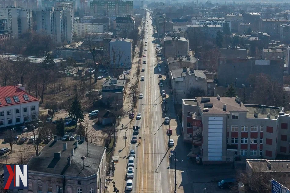 "Zdjęcie przedstawiające ul. Rzgowską w Łodzi, gdzie w kwietniu 2023 roku rozpocznie się przebudowa. W tle widoczne oznakowanie drogi oraz sprzęt budowlany, co symbolizuje nadchodzące remonty. Ważna arteria zostanie zamknięta na odcinku od ul. Dąbrowskiego do ul. Paderewskiego, co wpłynie na ruch drogowy w mieście."