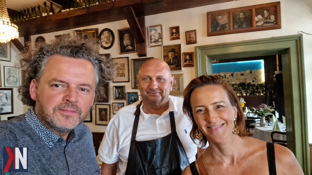Paweł Zyner, właściciel Anatewki, uśmiechnięty w restauracyjnej kuchni, otoczony przez aromatyczne potrawy i zespół pracowników, z pasją opowiada o swoich doświadczeniach w branży gastronomicznej, miłości do Łodzi oraz filozofii życia, w której restauracja odgrywa kluczową rolę.