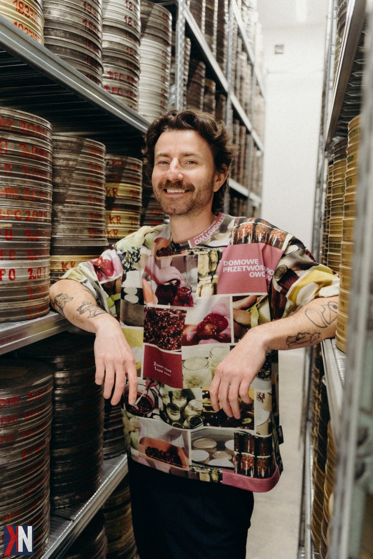 "Zdjęcie przedstawia Macieja Lebiedowicza, współwłaściciela marki odzieżowej i kawiarni 'Pan tu nie stał', w przytulnej atmosferze jego lokalu przy OFF Piotrkowska. W tle można dostrzec unikalne wnętrze kawiarni, które zachęca do spędzenia czasu w gronie przyjaciół. Artykuł eksploruje historię zadowolenia związku z marką oraz inspiracje, które stoją za jej sukcesem."